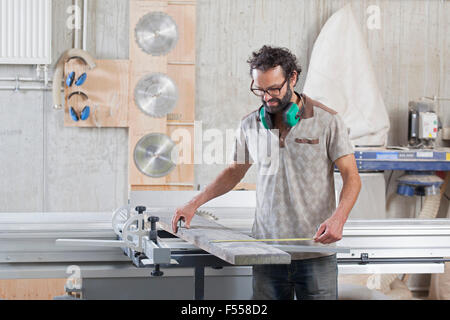 Carpintero macho en el taller de madera de medición Foto de stock