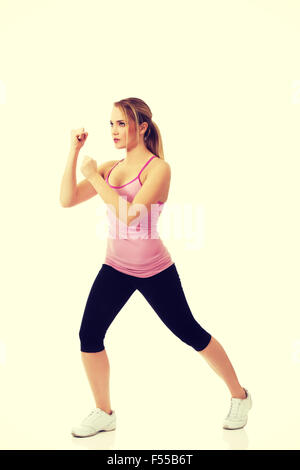 Mujer joven en kick fitness pose. Foto de stock