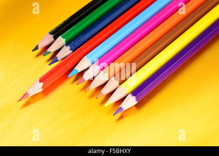 Lápices de color con diferentes colores sobre fondo dorado