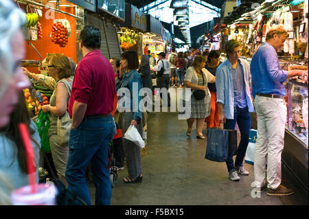 Compradores navegando puestos en el Mercado de la Boqueria Barcelona Cataluña España ES Foto de stock