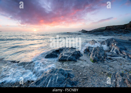 Impresionante puesta de sol sobre la playa rocosa a Trevone bahía cerca de Padstow en Cornwall.