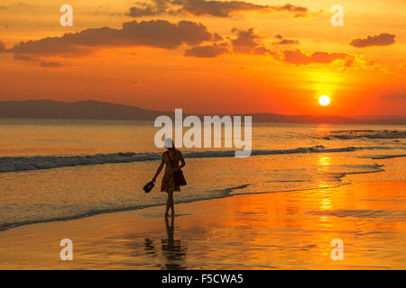 Mujer joven Radhnagar al atardecer en la playa, una de las playas más bellas del mundo Foto de stock