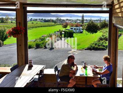 Cata de vinos en pareja en la bodega de una finca en la bahía de Mercury, la bahía de Mercury, la península de Coromandel, Isla del Norte, Nueva Zelanda Foto de stock