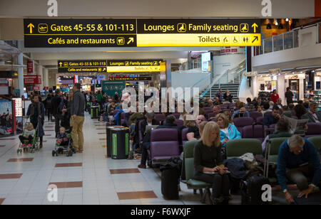 Personas esperando en la sala de embarque, la terminal norte del aeropuerto de Gatwick, Londres, Inglaterra, Reino Unido. Foto de stock