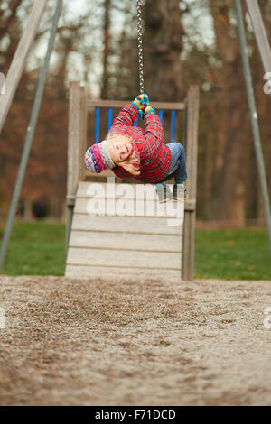 Niño Niña rids sobre Flying Fox el equipo para jugar en un playground para niños. Balancín, correderas, volando, cuerda de diapositiva Foto de stock
