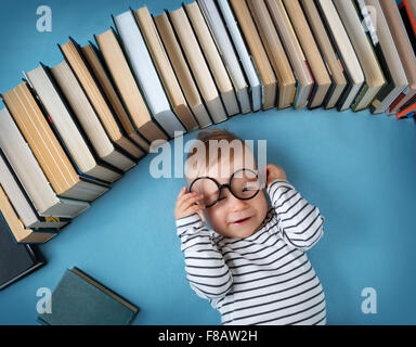 Bebé de Un año de edad con spectackles y libros