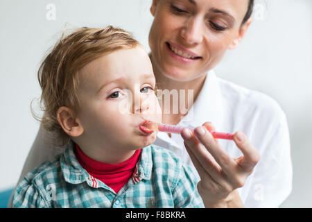 2 años de edad tomando jarabe con una pipeta. Foto de stock