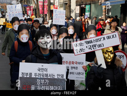 Protesta contra Park Geun-Hye, Dec 5, 2015 : personas con máscaras de marzo durante un mitin anti-gobierno en Seúl, Corea del Sur. "El campamento del pueblo para levantarse y luchando", que representan a diversos grupos de campesinos, los estudiantes, los trabajadores y los pobres, demostró el 5 de diciembre de 2015, para oponerse al régimen del parque para cambiar el mercado laboral que los manifestantes insisten, facilitará el despido y más trabajadores temporales y de monopolizar la autoría de los libros de historia. Las personas llevaban máscaras en la manifestación para denunciar Park que comparó recientemente manifestantes locales en máscaras para ISIS. El organizador dijo que 50.000 personas Foto de stock