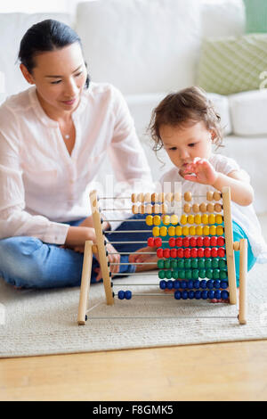 La madre y el bebé niña jugando con abacus Foto de stock