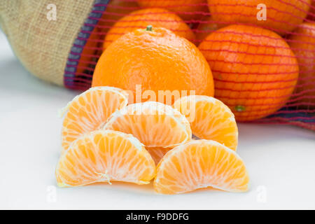 Las mandarinas peladas con una bolsa llena Foto de stock