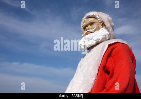 Un maniquí de Santa Claus con el ceño fruncido preocupado inquietos buscando expresión foto al aire libre bajo un cielo azul Foto de stock