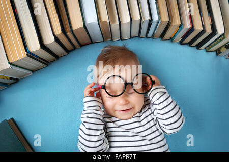 Bebé de Un año de edad con spectackles y libros