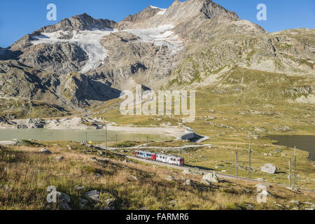 El tren expreso en Lago Bianco en el Bernina Pass, Grisons, Suiza Foto de stock