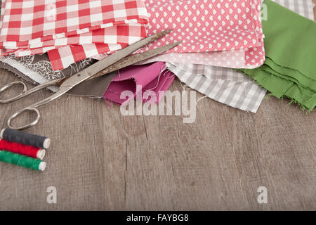 Las coloridas telas y accesorios para adaptar la mentira sobre un metro de madera Foto de stock