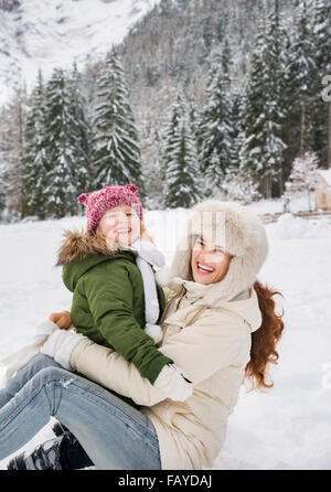 Invierno afuera puede ser cuento de hadas-maker para niños o adultos. Retrato de la madre y el niño sonriente jugando afuera en la fro Foto de stock