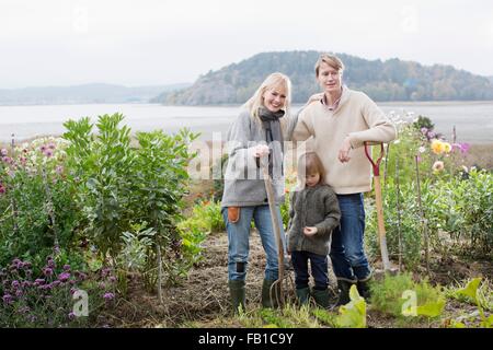 Retrato de pareja e hijo cavar jardín orgánico, Orust, Suecia