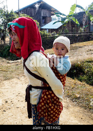 Una mujer en Putao lleva un bebé en su espalda.