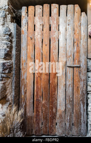 Antigua puerta hecha de tablas de madera áspera juntos verticalmente.