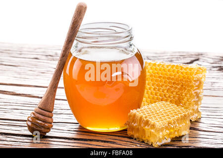 Miel en el fondo de panal. Miel en un tarro de vidrio y panal de miel  Fotografía de stock - Alamy