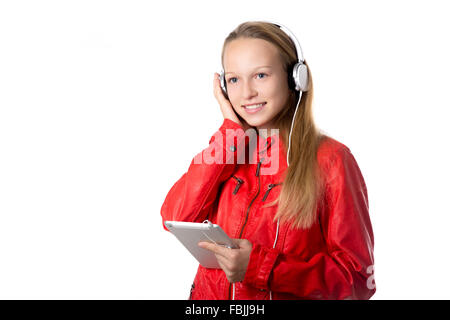 Retrato de feliz hermosa chica adolescente casual vistiendo chaqueta de cuero rojo y auriculares utilizando modernas tablet, amable sonriendo Foto de stock