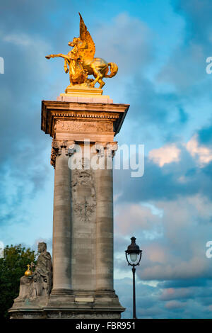 Los últimos rayos de sol por la noche en la columna de puente Alexandre III, París, Francia