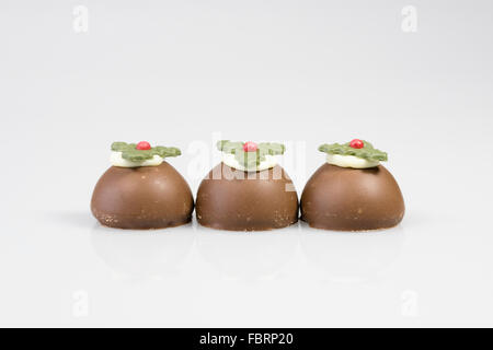 Tres chocolate budines de Navidad sobre un fondo blanco. Foto de stock