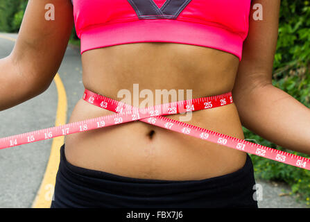 medida de cintura de vientre de niña con cinta amarilla y medida en  pulgadas Fotografía de stock - Alamy