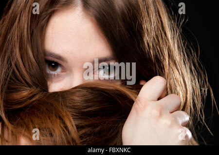 Closeup mujer cubre el rostro por largos pelos marrones