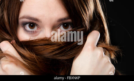 Closeup mujer cubre el rostro por largos pelos marrones