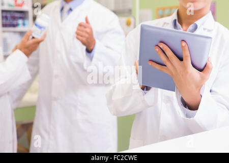 Equipo de farmacéutico con tablet y manteniendo la medicación Foto de stock