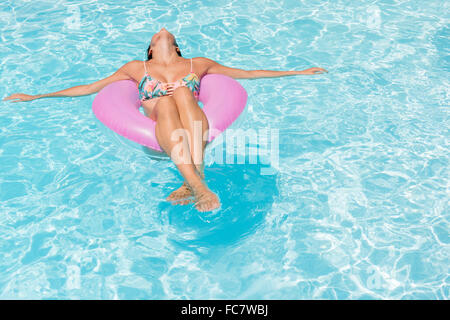 Mujer caucásica flotando en la piscina