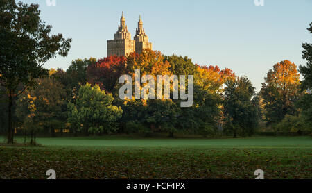 Central Park Sheep Meadow en pleno otoño colores con las torres de San Remo en la luz del amanecer. Otoño en Manhattan, Ciudad de Nueva York