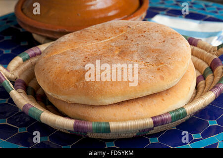 Fresco pan marroquí en una canasta y tagine sobre la mesa Foto de stock