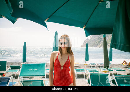 Retrato de joven mujer vistiendo el traje de baño rojo en la playa