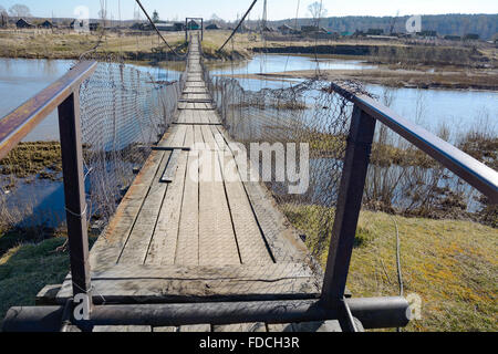 La suspensión del puente peatonal cruzando el río, en la aldea de Chebula Verkh-Chebula, región Kemerovo, Siberia, Rusia