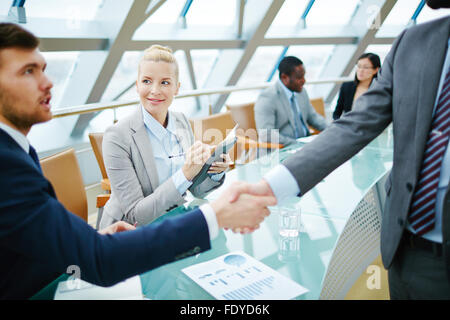 Feliz empresaria mirando uno de empresario handshaking con partner Foto de stock