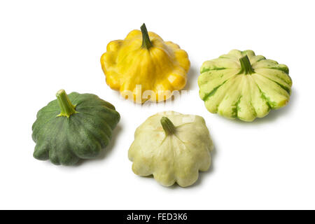 Cuatro tipos de calabaza patty pan fresco sobre fondo blanco.