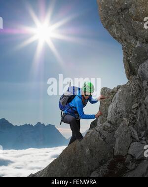 Escalador femenina sobre la pared rocosa al atardecer, Mont Blanc, Francia Foto de stock
