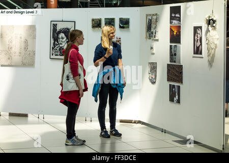 Dos jóvenes mujeres mirando obras de arte en exhibición en Edificio Fórum, Norwich, Norfolk, UK Foto de stock