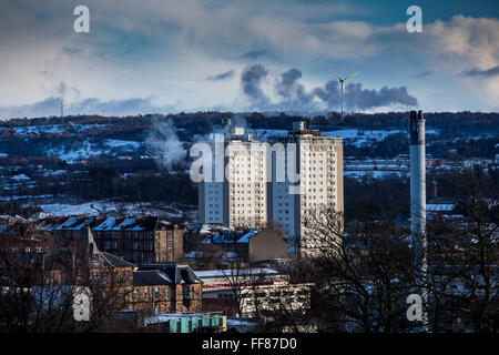Dos bloques de apartamentos, una chimenea de fumadores y una turbina eólica en Glasgow al lado Sur tomado de Queens Park, Glasgow. Foto de stock