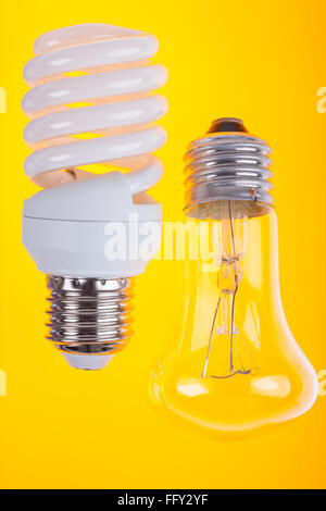 Dos tipos de bombillas sobre fondo amarillo Foto de stock