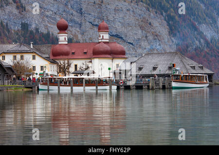 Barco con turistas en frente del Sankt Bartholomä / la Iglesia de San Bartolomé en el lago Königssee, Berchtesgaden NP, Alemania Foto de stock