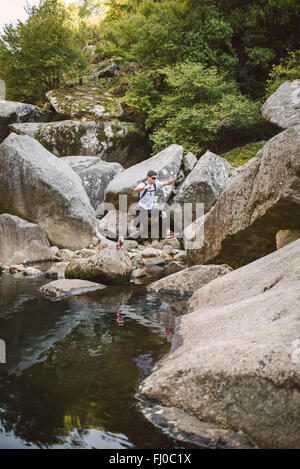España, A Capela, ultra trail runner cruzar un río Foto de stock