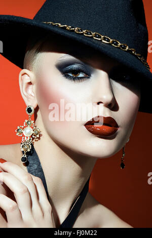 Rock girl en un sombrero negro con labios rojos y ojos oscuros en un corsé. Rock girl en un sombrero negro con labios rojos y ojos oscuros en un corsé.