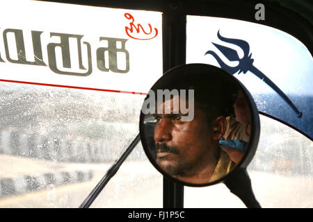 Primer plano de la cara de un conductor de rickshaw en espejo, Madurai, India