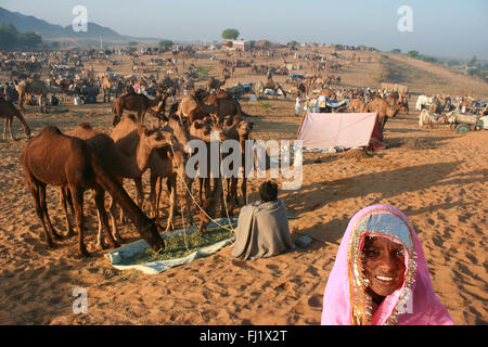 Los camellos y sus propietarios durante Pushkar mela feria de camellos en Rajasthan