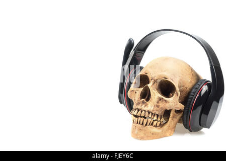 Cráneo humano en auriculares aislado sobre un fondo blanco. Foto de stock
