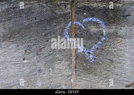 El amor del corazón de tiza azul sobre una pared de piedra Foto de stock