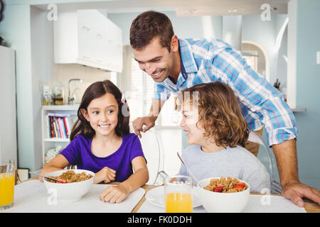 Hombre feliz con niños desayunando Foto de stock