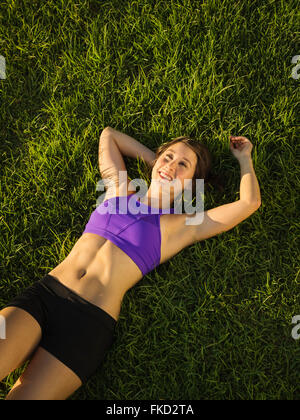 Mujer joven acostado sobre el césped Foto de stock
